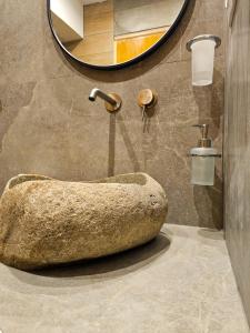 baño con lavabo grande de roca y espejo en Villa Zoi, en Paralia Katerinis