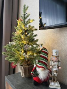 a small christmas tree on a table next to a figurine at Vienibas Apartaments in Krāslava