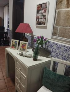 a table with a lamp and pictures on it at Casa do Adro- Douro in Peso da Régua