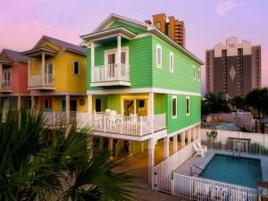 una casa colorida con una piscina frente a ella en Green Family Bungalow! Beach Access, Pool, & Fishing Dock, en Gulf Shores