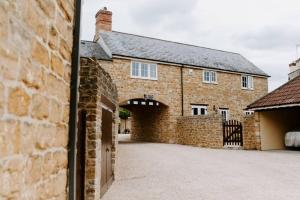 a brick building with a gate and a garage at The Loft in Sherborne: central with parking in Sherborne