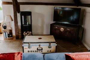 a living room with a tv and a trunk at The Loft in Sherborne: central with parking in Sherborne