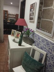 un tavolo con una lampada e immagini sopra di Casa do Adro- Douro a Peso da Régua