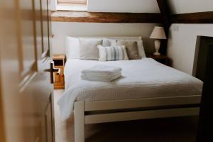 a bedroom with a bed with white sheets and pillows at The Loft in Sherborne: central with parking in Sherborne