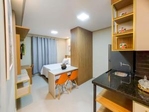 a room with a bed and a desk and a kitchen at APARTAMENTO FLAT STUDIO WEST FIT 711 a in Mossoró