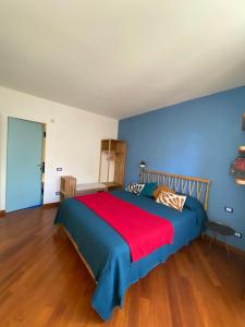 een slaapkamer met een groot bed en een rode deken bij La Porta Azzurra - Casa Vacanze in Como