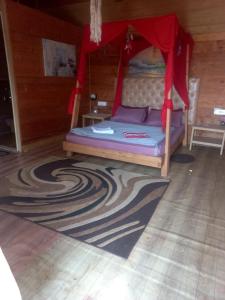 Bett mit Baldachin in einem Zimmer mit Teppich in der Unterkunft Love Temple Beach Resort in Arambol