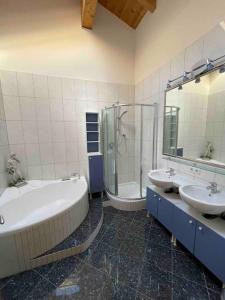 a bathroom with two sinks and a tub and a shower at Haus Peppone in Mathon