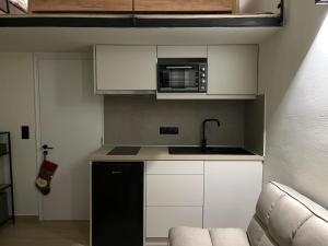 a small kitchen with a sink and a microwave at Nikitas loft in Kalamata
