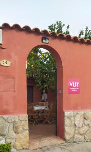 un arco en un edificio con una mesa de picnic en Jinoba25, en Castillo de Bayuela