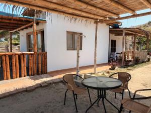 eine Terrasse mit einem Tisch und Stühlen vor einem Haus in der Unterkunft Bungalows Sol y Mar in Canoas De Punta Sal