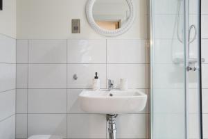 a white bathroom with a sink and a mirror at Outside Balcony Lux Apartment in Bradford