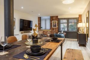 a living room with a dining room table with wine glasses at Outside Balcony Lux Apartment in Bradford