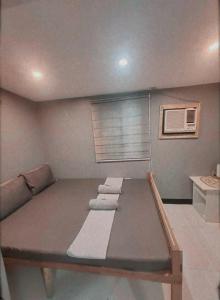 uma cama num quarto com uma janela com toalhas em Mantilla Hostel em Coron