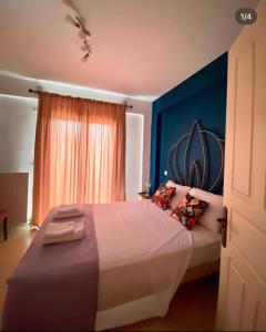 sypialnia z dużym łóżkiem z niebieską ścianą w obiekcie Dominique Rooms Meteora w Kalambace