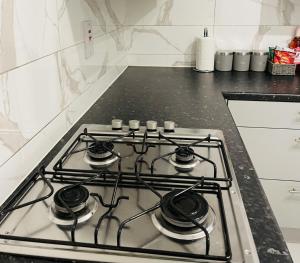 a stove top with four burners in a kitchen at Walk to Lcy Airport Excel Dlr 1Br Flat in London