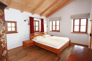 ein Schlafzimmer mit einem großen Bett in einem Zimmer mit Fenstern in der Unterkunft Springerhof in Schechen