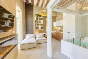 a living room with a couch and a kitchen at Luxury Suite - Jacuzzi et Sauna in Arpajon