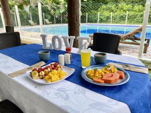 uma mesa com dois pratos de comida para o pequeno almoço em Hostel Glamping Mistiko Safari - Carmen de apicala em Carmen de Apicalá