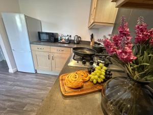 una cocina con una tabla de cortar con comida y flores en No. 19 by Blue Skies Stays, en Stockton-on-Tees