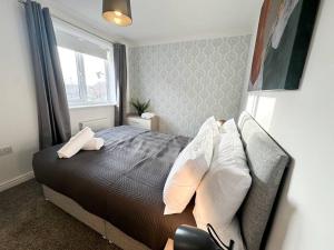 Un dormitorio con una cama con almohadas y una ventana. en No. 19 by Blue Skies Stays, en Stockton-on-Tees 10 fotos más