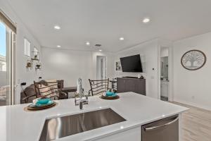 eine Küche mit einem Waschbecken und ein Wohnzimmer in der Unterkunft AT YOUR SERVICE - Modern Amenities, Urban Location, Sophisticated Style in Phoenix