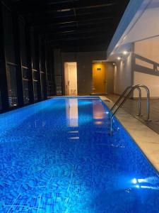 a large blue swimming pool in a building at Cozy flat in Financial District! in Bogotá