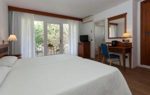 a hotel room with a bed and a desk and a window at Hotel Araxa - Adults Only in Palma de Mallorca