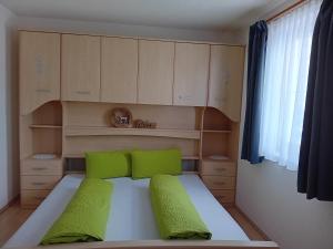 niewielka sypialnia z łóżkiem z zielonymi poduszkami w obiekcie Ferienwohnung Familie Mark w mieście Pfunds