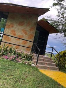 a building with stairs and flowers in the grass at Suite Pacandé , cerca al desierto de la tatacoa in Aipe
