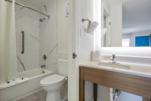 ein weißes Badezimmer mit Toilette und Waschbecken in der Unterkunft Beachside Resort Hotel in Gulf Shores + 16 Fotos