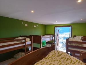 Pokój z zielonymi ścianami i łóżkami piętrowymi z oknem w obiekcie Mora de Nuei w mieście Aínsa