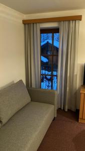 uma sala de estar com um sofá e uma janela em Appartement Stahlhammer em Flachau