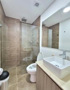 La salle de bains est pourvue de toilettes, d'un lavabo et d'une douche. dans l'établissement New Luxury 3 Bedroom Apartment in Great Area., à Medellín