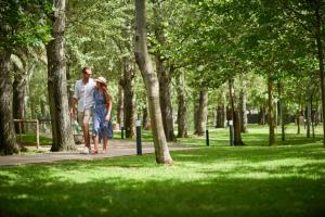 a man and a woman walking in a park at Calaserena Resort in Geremèas