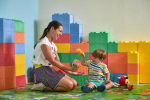 a woman and a child playing with a toy at Calaserena Resort in Geremèas