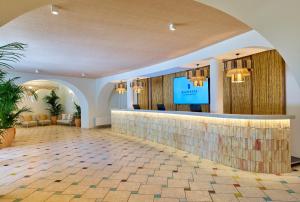 a hotel lobby with a bar and a flat screen tv at Calaserena Resort in Geremèas