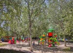 a playground in a park with children playing in it at Calaserena Resort in Geremèas