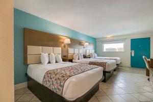 Zwei Betten in einem Hotelzimmer mit blauen Wänden in der Unterkunft Beachside Resort Hotel in Gulf Shores