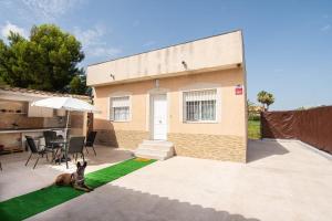 a dog sitting on a lawn in front of a house at La Deseada in Murcia