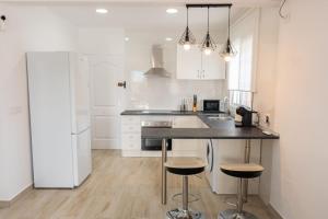 a kitchen with white cabinets and a black counter top at La Deseada in Murcia