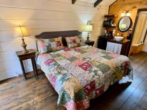a bedroom with a bed with a quilt on it at Tiny Home Cottage Near the Smokies #3 Ingrid in Sevierville