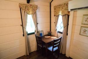 a dining room with a table and two windows at Tiny Home Cottage Near the Smokies #3 Ingrid in Sevierville