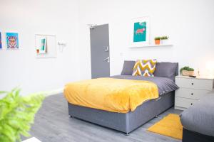 a bedroom with a bed with a yellow blanket at Chill Nexus Oasis in Liverpool