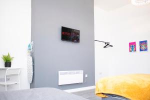 1 dormitorio con 1 cama y TV en la pared en Chill Nexus Oasis, en Liverpool