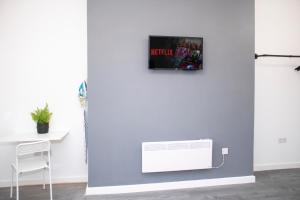 a room with a wall with a tv on the wall at Chill Nexus Oasis in Liverpool