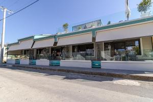 a building with tables and chairs on a street at STREET 90 Lux Aparts in Keramoti