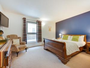 a bedroom with a large bed and a chair at 2 Bed in Fort Augustus 80700 in Fort Augustus