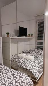 2 łóżka w pokoju z lustrem w obiekcie Życzliwy Apartament z garażem w Warszawie