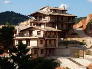 a building on a hill with a mountain at Casa El Mirador in Beceite